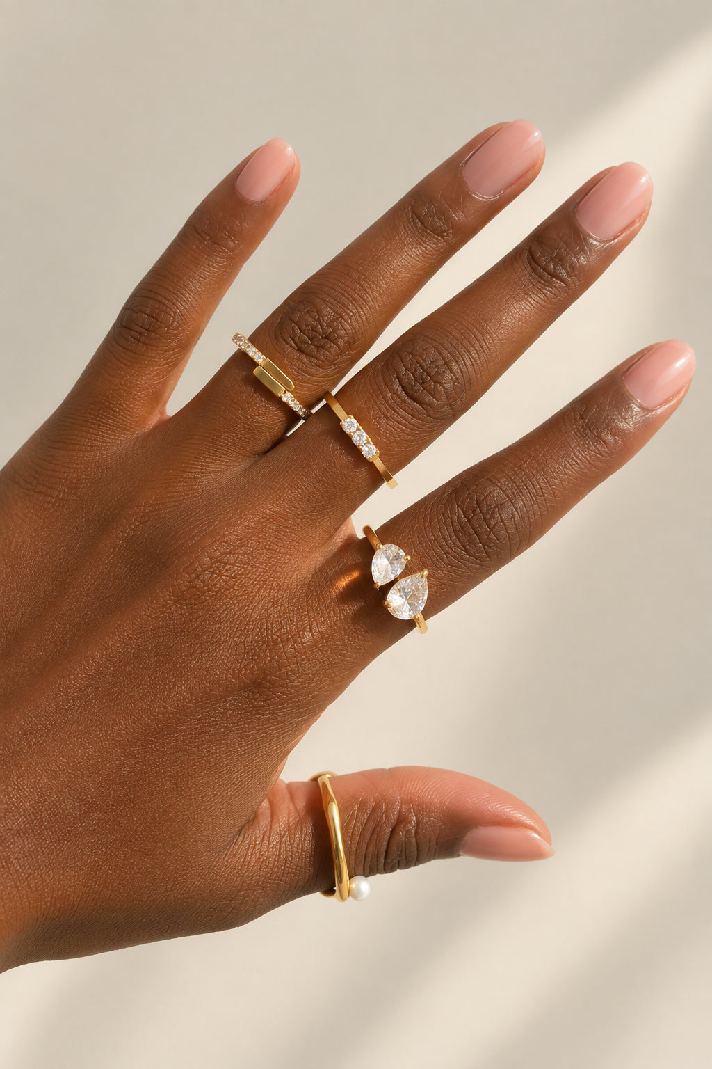 Gros plan d'une bague dorée Toi & Moi avec deux pierres taille poire.